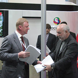 Глава Роснано Анатолий Чубайс (слева) и основной владелец ГК "Ренова" Виктор Вексельберг обмениваются копиями соглашения